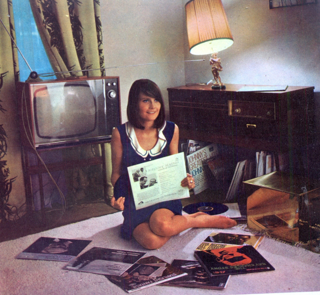 a girl sitting on the floor with records